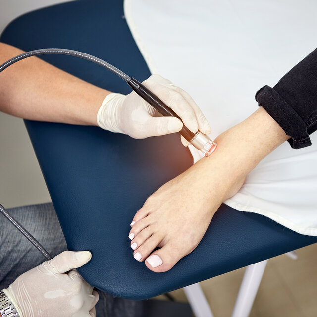 Behandlung des Fußes mit Laser-Therapie