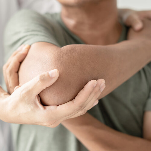 Therapeut untersucht Ellbogengelenk